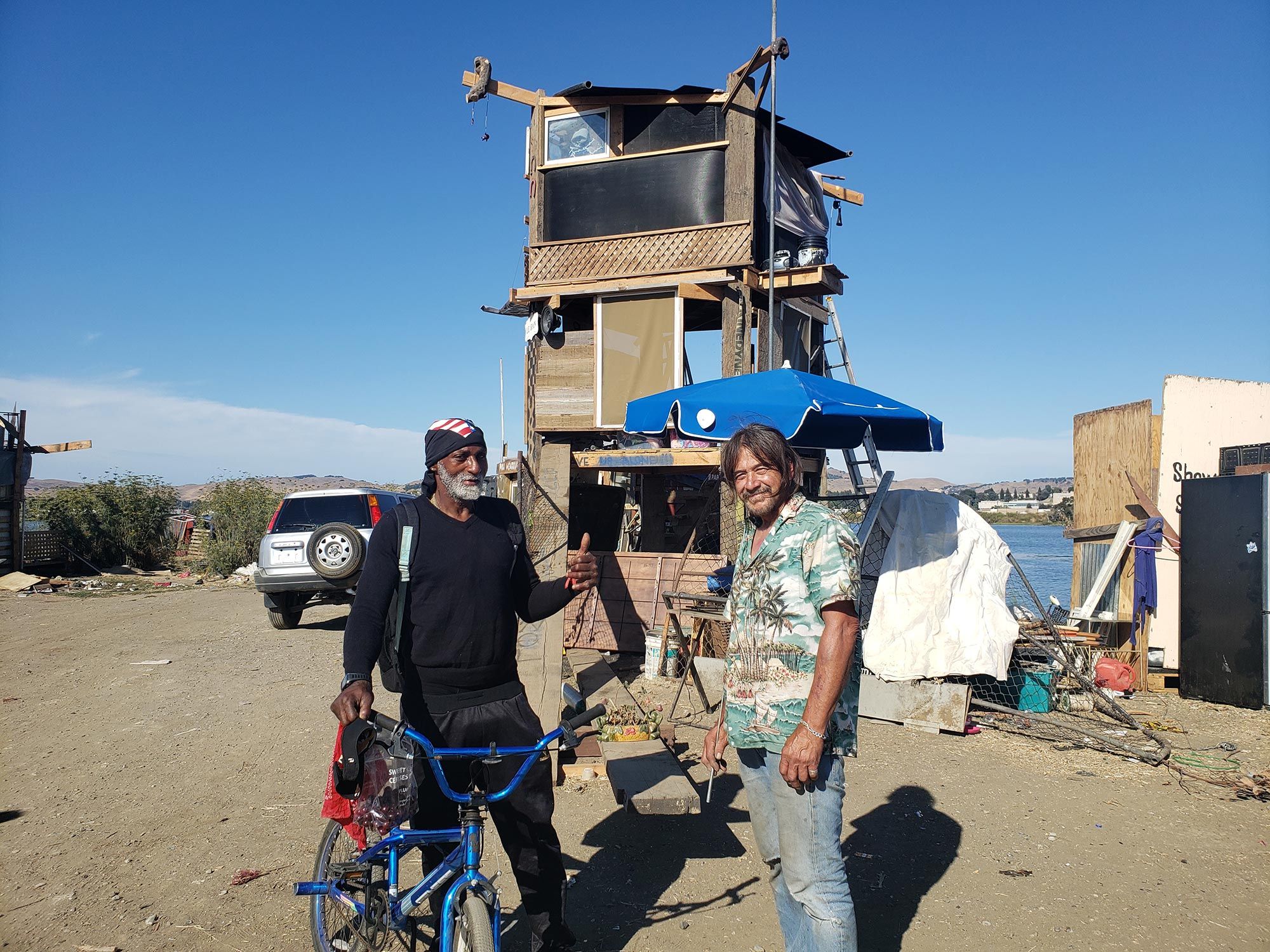 Chat Alberto, right, discusses dinner plans with another resident of a spit of land in White Slough.