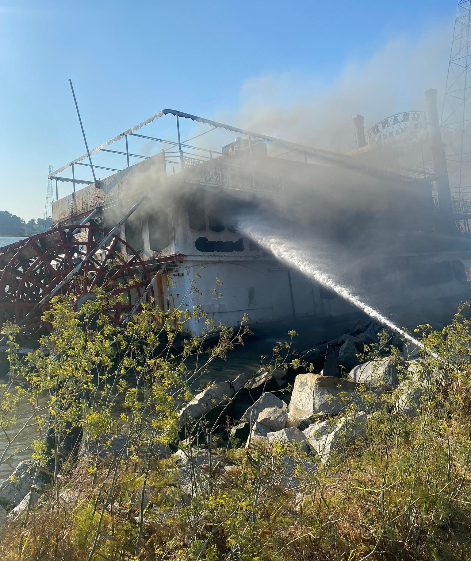 Firefighters extinguish the blaze on the Grand Romance riverboat on Saturday.
