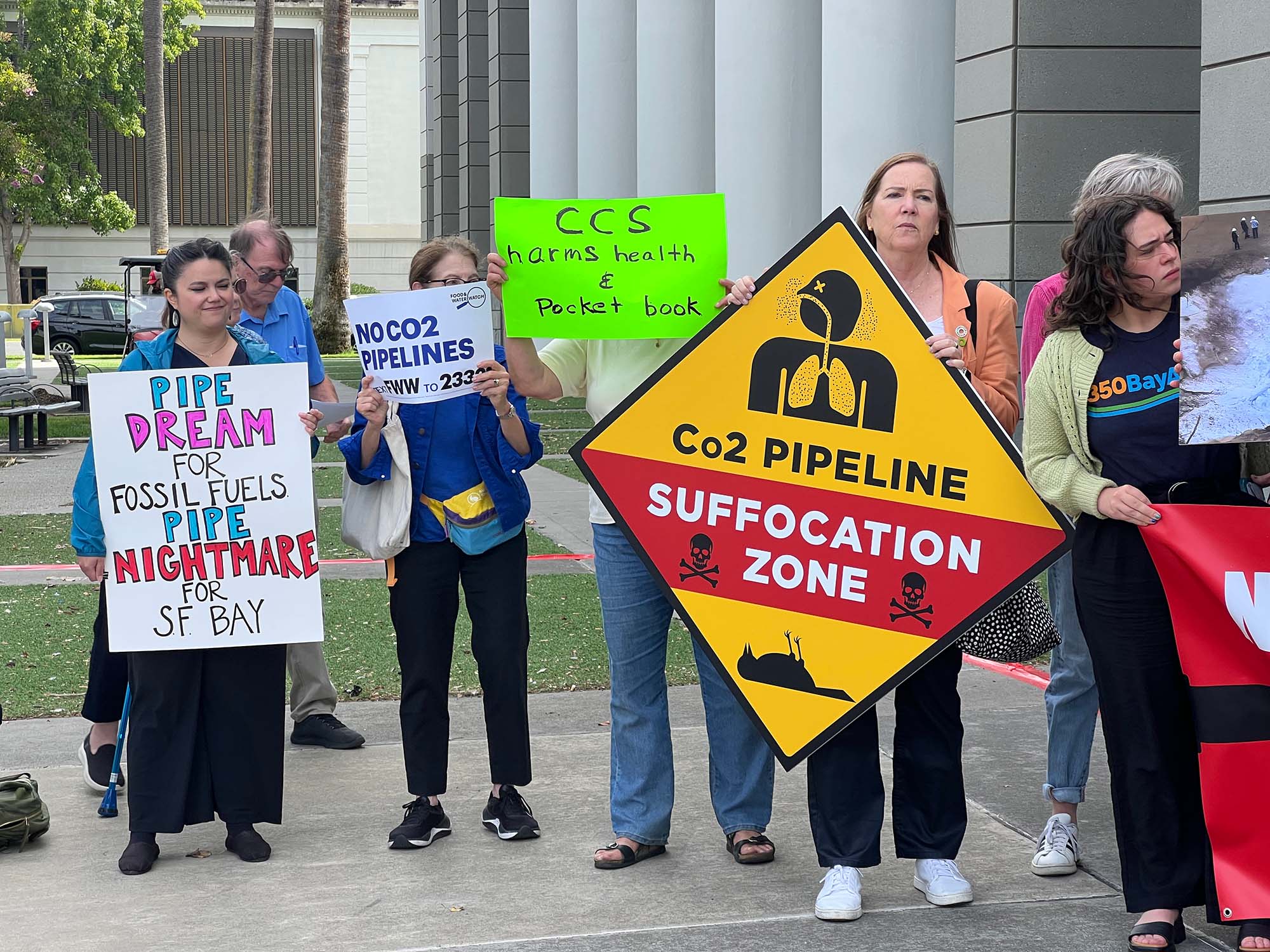 Protesters holding signs opposing the proposed carbon dioxide  pipeline.