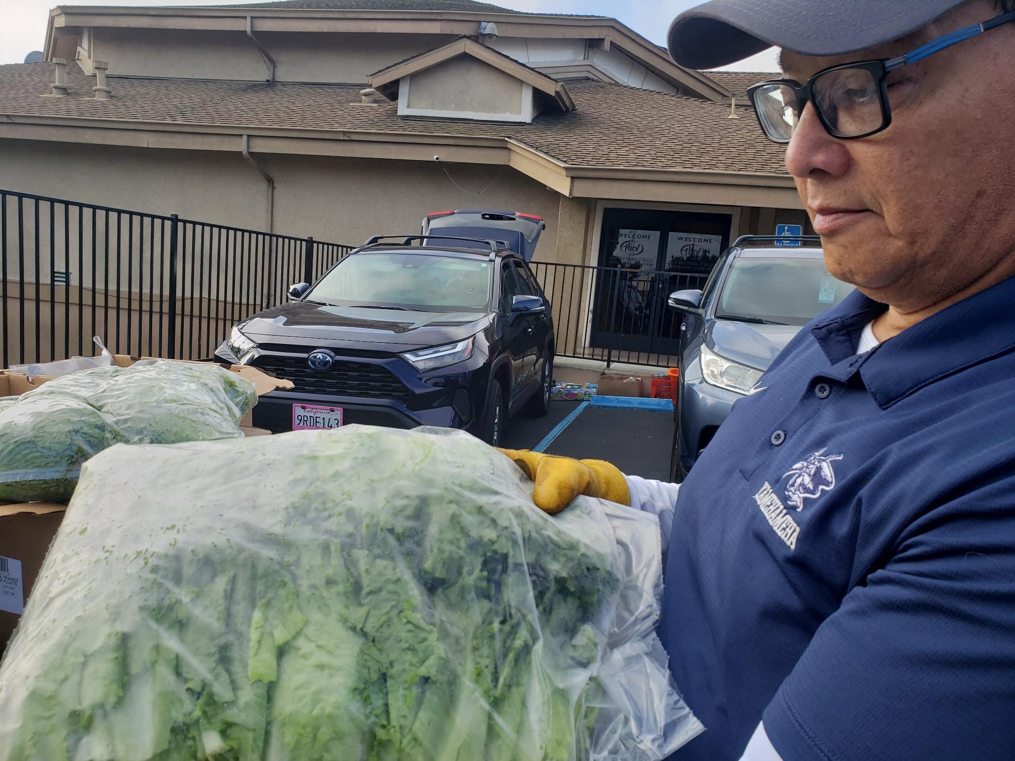 A volunteer carries produce at a food distribution Saturday