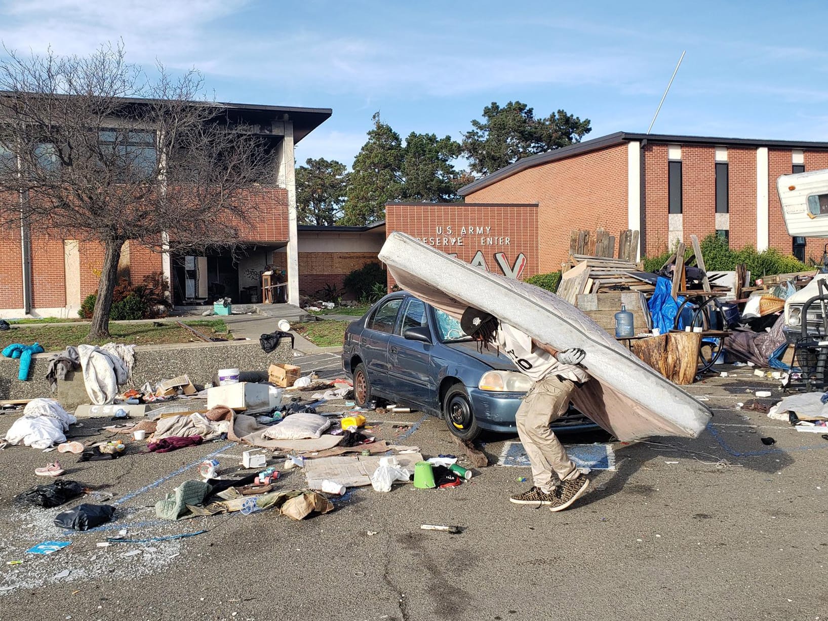 Jaisaun Harris, 48, carries a mattress during a cleanup of a former U.S. Army Reserve site in Vallejo on Monday.