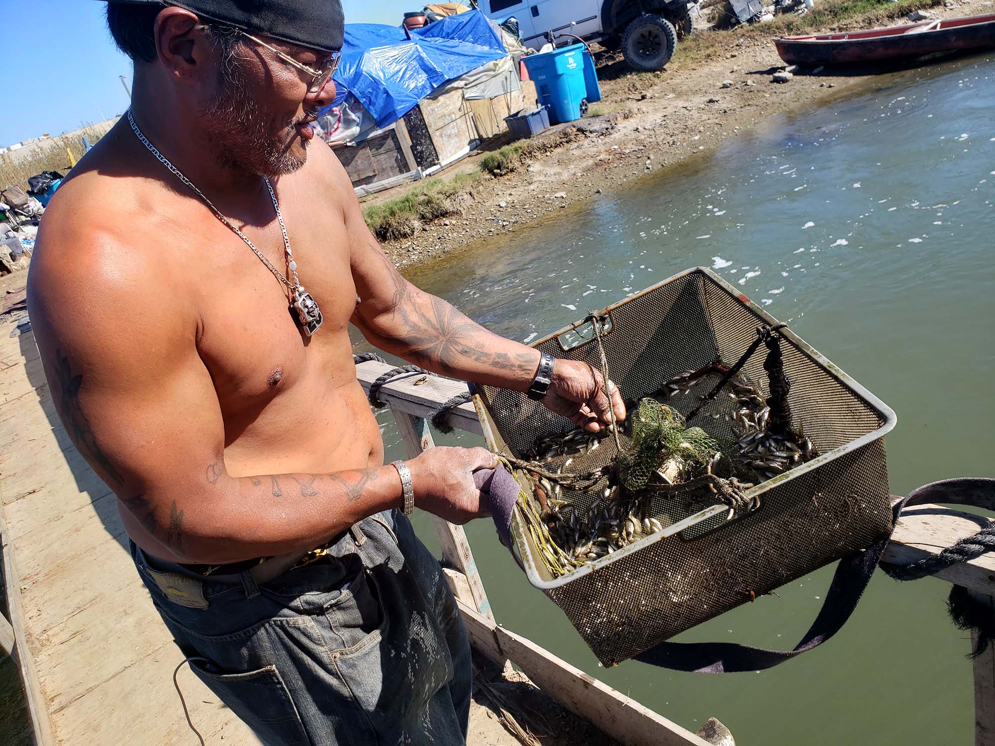 Victor Mena catches bait fish off the bridge in White Slough.