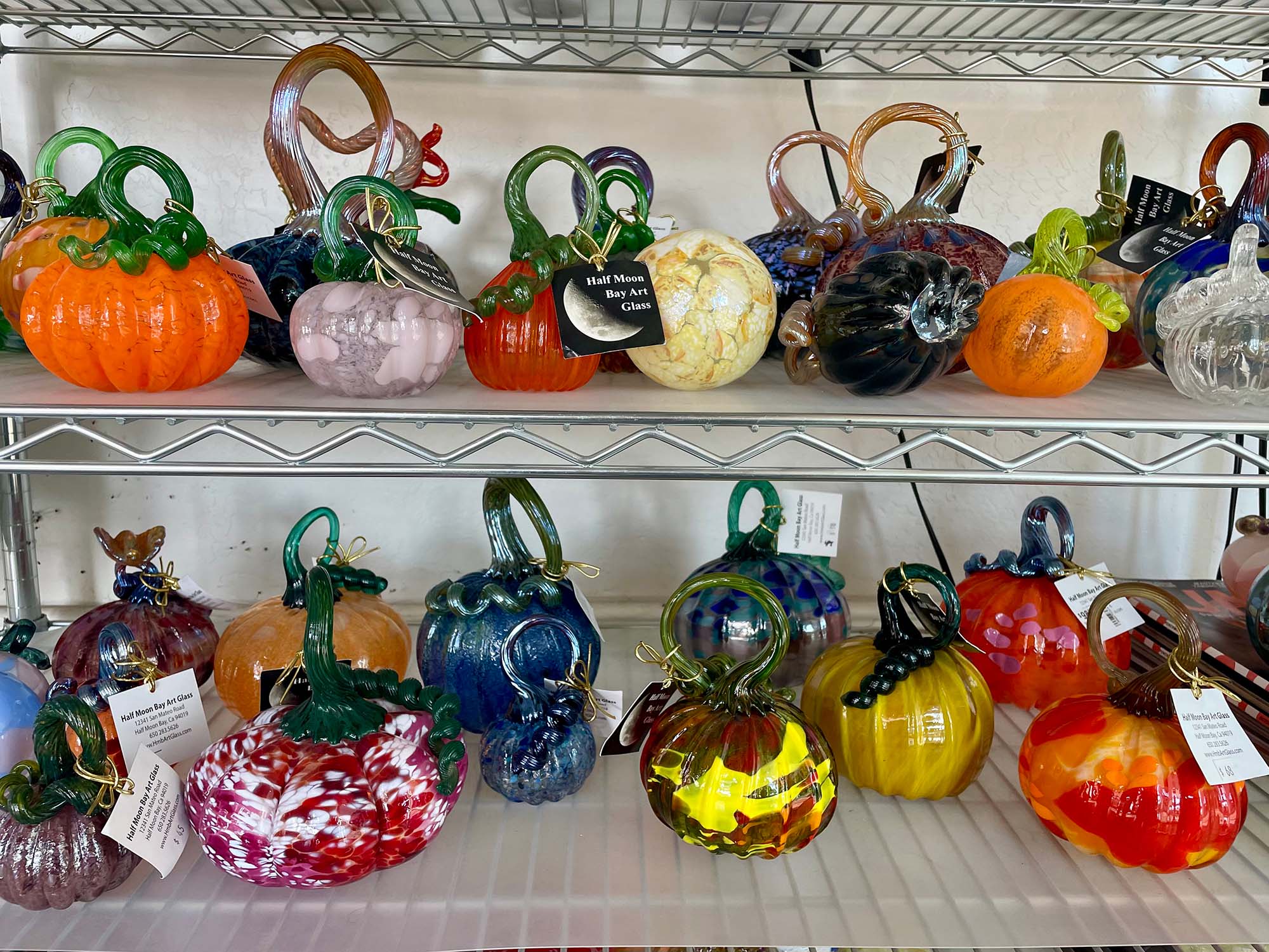 A shelf with glass pumpkins